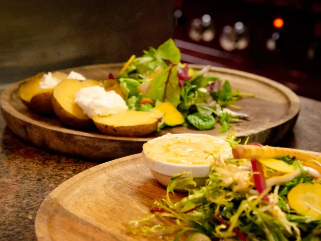 A cheese and salad dish on a wooden tray