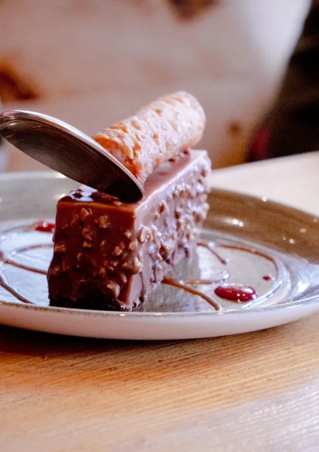 Un entremet au chocolat sur une assiette blanche