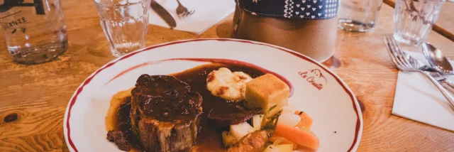 Un plat de viande en sauce dans une assiette blanche