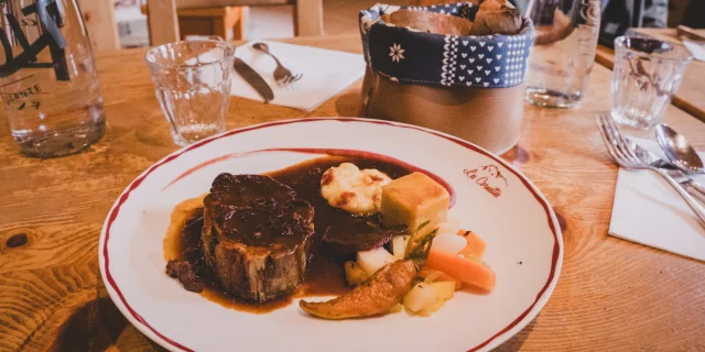 Un plat de viande en sauce dans une assiette blanche