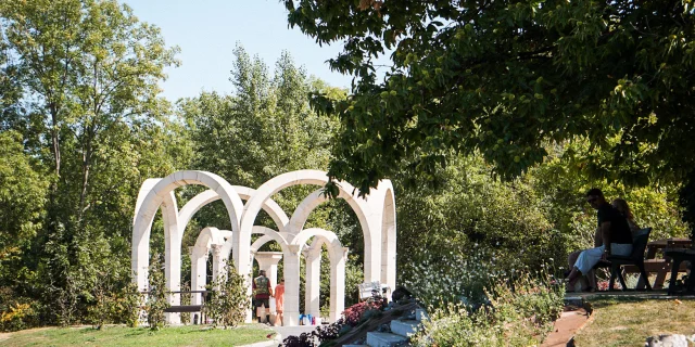 Een bron tussen de bomen gevormd door witte bogen