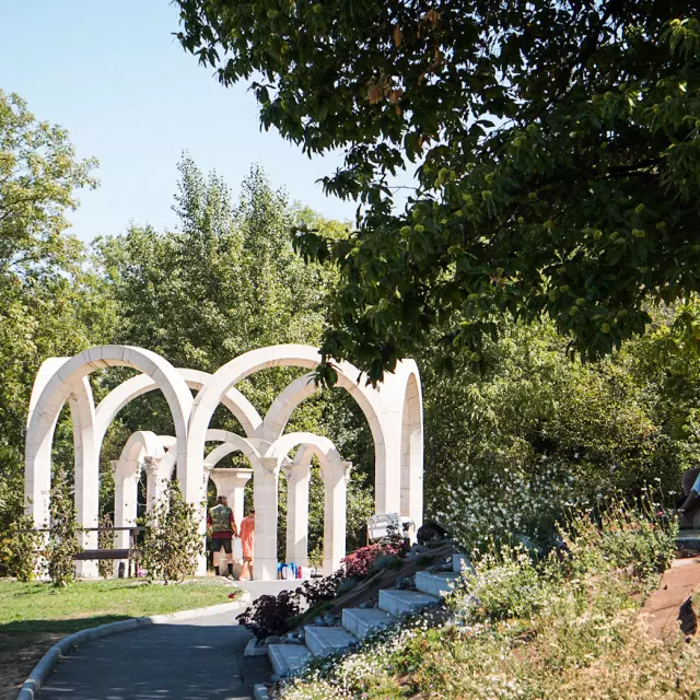 A spring among the trees formed by white arches